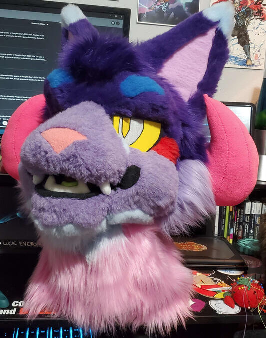 The head of Bleeding Heart, a brightly colored cat beast with curled pink horns.