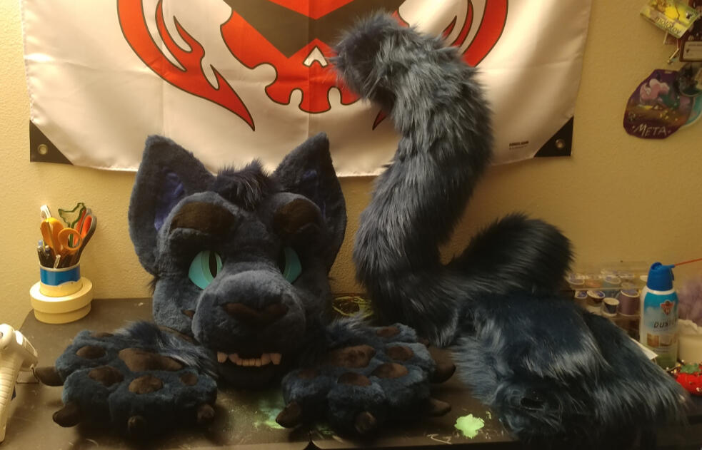 The head, tail, handpaws, and arm sleeves of Vesper, a displacer beast with dark blue fur.