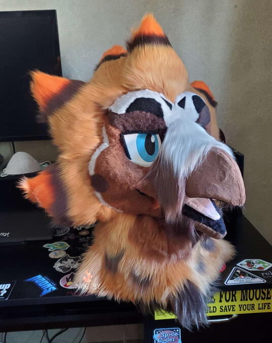 The fursuit head of a bearded vulture character.